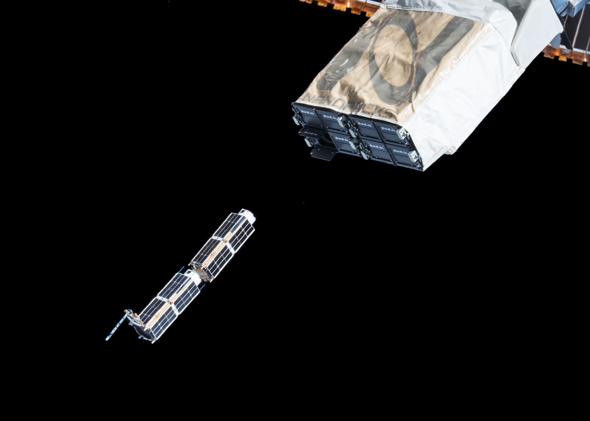 A group of CubeSats being deployed into Low Earth Orbit from the International Space Station, February 2015.